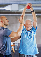 Lift for longevity. Shot of a senior man working out with the help of a trainer.