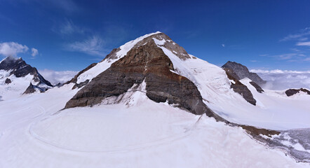impressive aerial panorama of the famous mountain trio Eiger,Mönch and Jungfrau mountain on a sunny day - obrazy, fototapety, plakaty