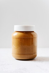 toasted tahini sesame sauce in jar on white table
