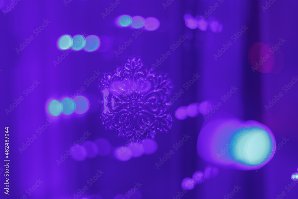 Poster blue bokeh on a lilac background with a blurred snowflake. glittering lights are not in sharpness. d