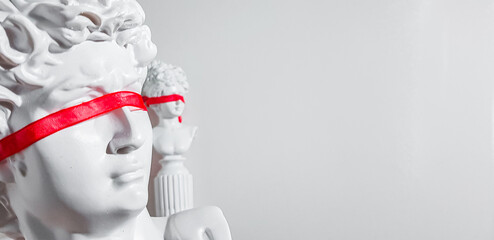 Fake bust of a man and a woman with a red ribbon on their eyes on a white background. The concept...