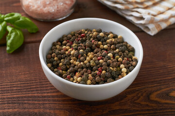 mixed peppercorns mix of peppercorns dried pepper in a bowl brown background pink salt