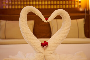 A swans made of towels on a bed in a hotel.
