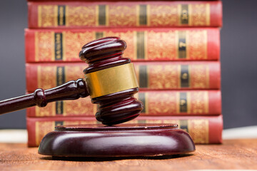Legal Law and Justice concept - Open law book with a wooden judges gavel on table in a courtroom or...