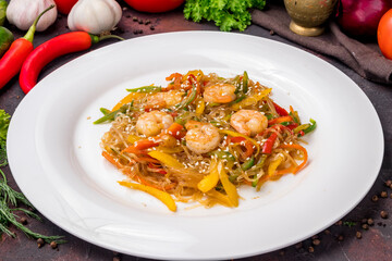 fried Rice noodles with shrimp and vegetables funchosa on dark table