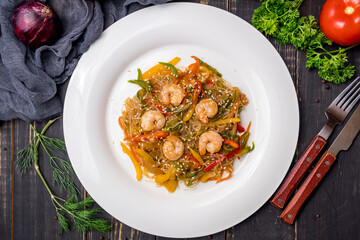 fried Rice noodles with shrimp and vegetables funchosa on dark table top view