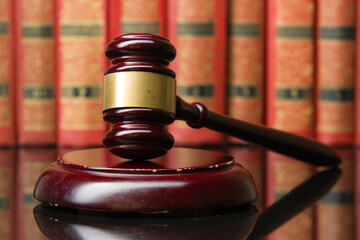 Legal Law and Justice concept - Open law book with a wooden judges gavel on table in a courtroom or...