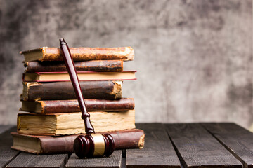 Legal Law and Justice concept - Old law book with a wooden judges gavel on table in a courtroom or law enforcement office. Copy space for text.