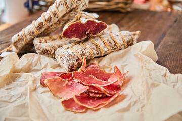 Raw-dried, dried sausage sliced lies on a wooden table. Traditional dried sausage, ready to eat, delicious breakfast. The concept of handmade meat products.