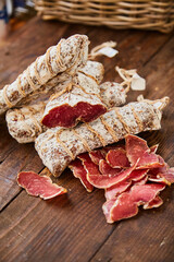 Raw-dried, dried sausage sliced lies on a wooden table. Traditional dried sausage, ready to eat, delicious breakfast. The concept of handmade meat products.