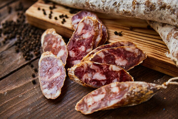 Factory for the production of meat products, boiled-smoked and dried sausages. Traditional spicy sausage, ready to eat, lies sliced on a wooden table. The concept of handmade meat products.