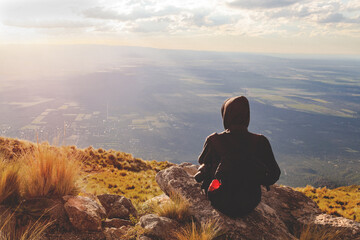 young woman on top of a mountain appreciating the landscape on a afternoon relaxed with her...