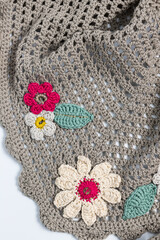Colorful fun crochet flowers in a beige crochet shawl.