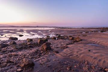 Landscape with rocks and stones on the Barbate beach next to the mouth of the Barbate river at sunrise, Cadiz, Andalusia, Spain