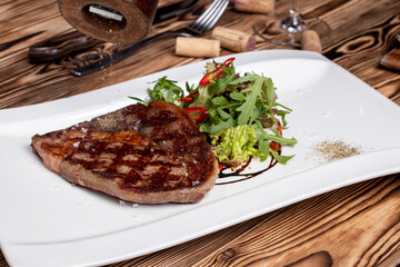 juicy Ribeye steak with vegetables on white plate