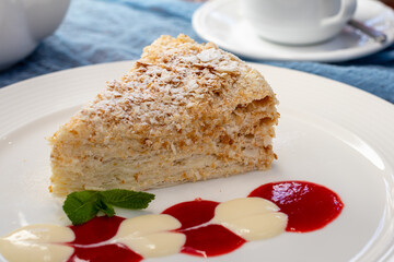 Napoleon dessert on plate with mint and sauce