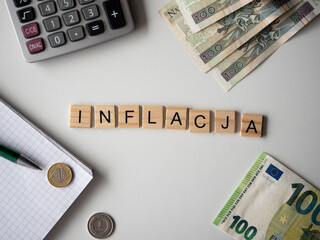 Inflacja - napis z drewnianych kostek, kryzys, wartość, cena złotówki, złoty, euro, kalkulator, pieniądze, długopis, flatlay 