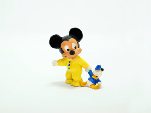 Baby Mickey Mouse. retro toy figure. Plastic doll. Vintage. Isolated. Cartoon character from Walt Disney Pictures Studios. Mickey is Minnie Mouse's boyfriend. Nephew. Baby with Donald Duck plush.
