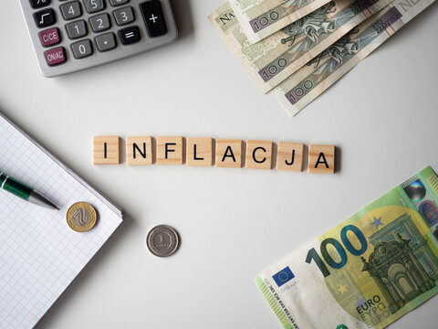 Inflacja - napis z drewnianych kostek, kryzys, wartość, cena złot&oacute;wki, złoty, euro, ​kalkulator, pieniądze, długopis, flatlay