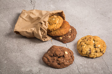 Delicious handmade chocolate chip cookies on a wooden cutting board on gray background