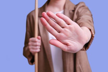 Woman teacher with hand gesture refusal on studio blue background, copy space