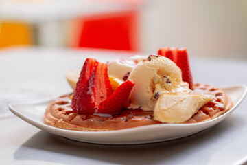 Delicious pancake with ice cream and fruits. Pancake dessert with strawberries and candy. Colombian food.