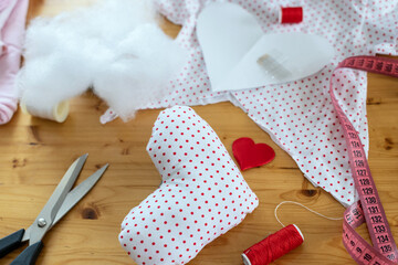 Sewing supplies. Recycle reuse zero waste concept. New life to old things, handmade heart gift. Valentine's Day diy craft, mini pillow hearts shape red and white colors with handmade