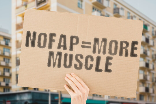 The phrase " Nofap = more muscle " on a banner in men's hand with blurred background. Intimacy. Masturbate. Condition. Manage. Power. Powerful