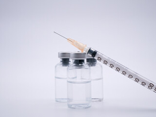 Three bottles of vaccine with syringe isolated on white background - 482477211