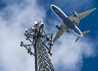 Mobile phone cell tower with 5G on the C Band frequencies with aircraft coming to land. Airlines...