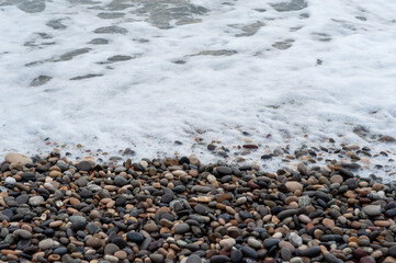 Runde Steine an einem Strand am Meer.