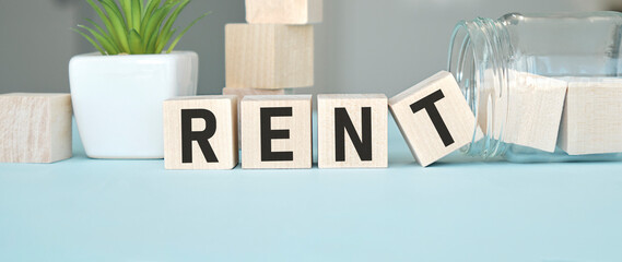 Wooden cubes with the word text RENT on blue background