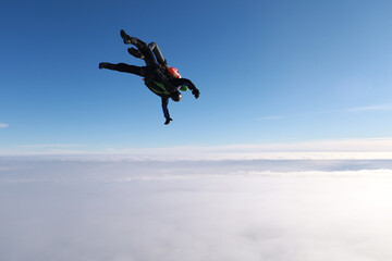 Fototapeta na wymiar Skydiving. Tandem jump isin the cloudy sky.