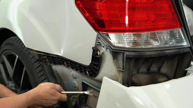 Video Process Of Disassembling Car For Further Repairing. Technician Removes Rear Bumper Retainer To Fix Car.