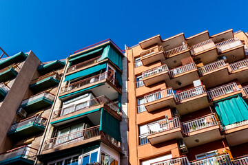 Exterior of an apartment building with balconies against a blue sky in Barcelona, Catalonia, Spain, Europe