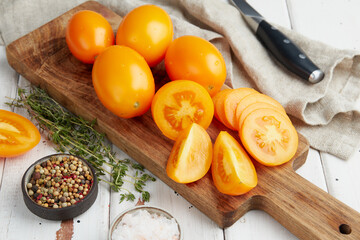 Fresh yellow tomatoes, close-up of fresh, ripe tomatoes on wooden background