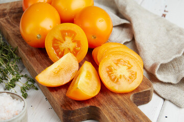 Fresh yellow tomatoes, close-up of fresh, ripe tomatoes on wooden background