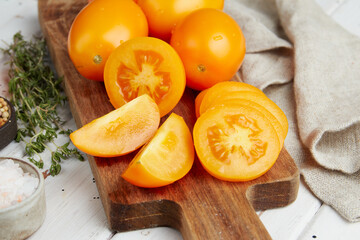 Fresh yellow tomatoes, close-up of fresh, ripe tomatoes on wooden background