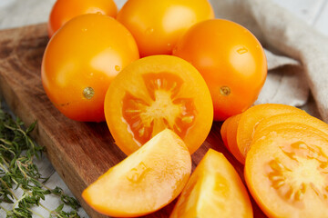 Fresh yellow tomatoes, close-up of fresh, ripe tomatoes on wooden background