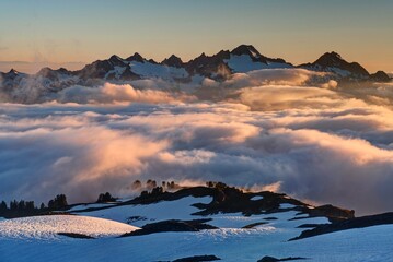 Clouds in mountain valley with snow covered peaks. View form above. Rocky mountain National park....