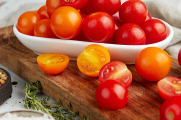 Fresh red cherry tomatoes on white wooden background