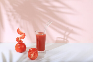 Modern still life with food, tomato juice and ingredients on a pink background with long hard shadows, minimal detox diet concept, summer vitamin drinks, selective focus, space for text