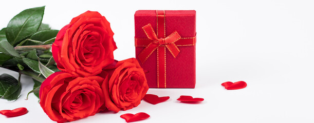 Bouquet of red roses and a gift box on a white background. Valentine's day concept.