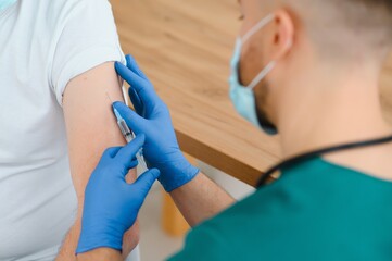 Doctor making a vaccination in the shoulder of patient Disabled person, Flu Vaccination Injection...