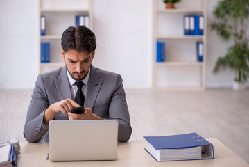 Naklejka premium Young male employee working in the office