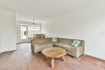 View of white living room in minimal style with sofa ,pillows and a wooden octagon table