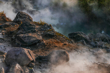 The play of light through the steam of a mountain hot spring