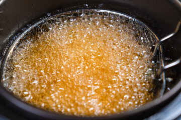 top view. oil boiling in deep fryer. in fryer cook shrimp in batter or potatoes.