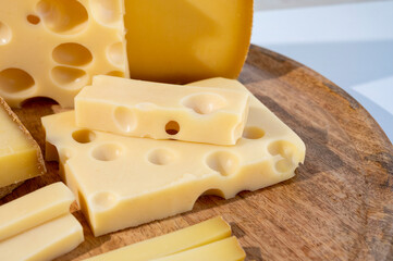 Cheese collection, hard French cheeses comte and emmentaler with round holes made from cow milk
