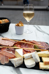 Lunch with glass of brut champagne sparkling wine and meat and cheese platter in street cafe in old central part of city Reims, Champagne, France